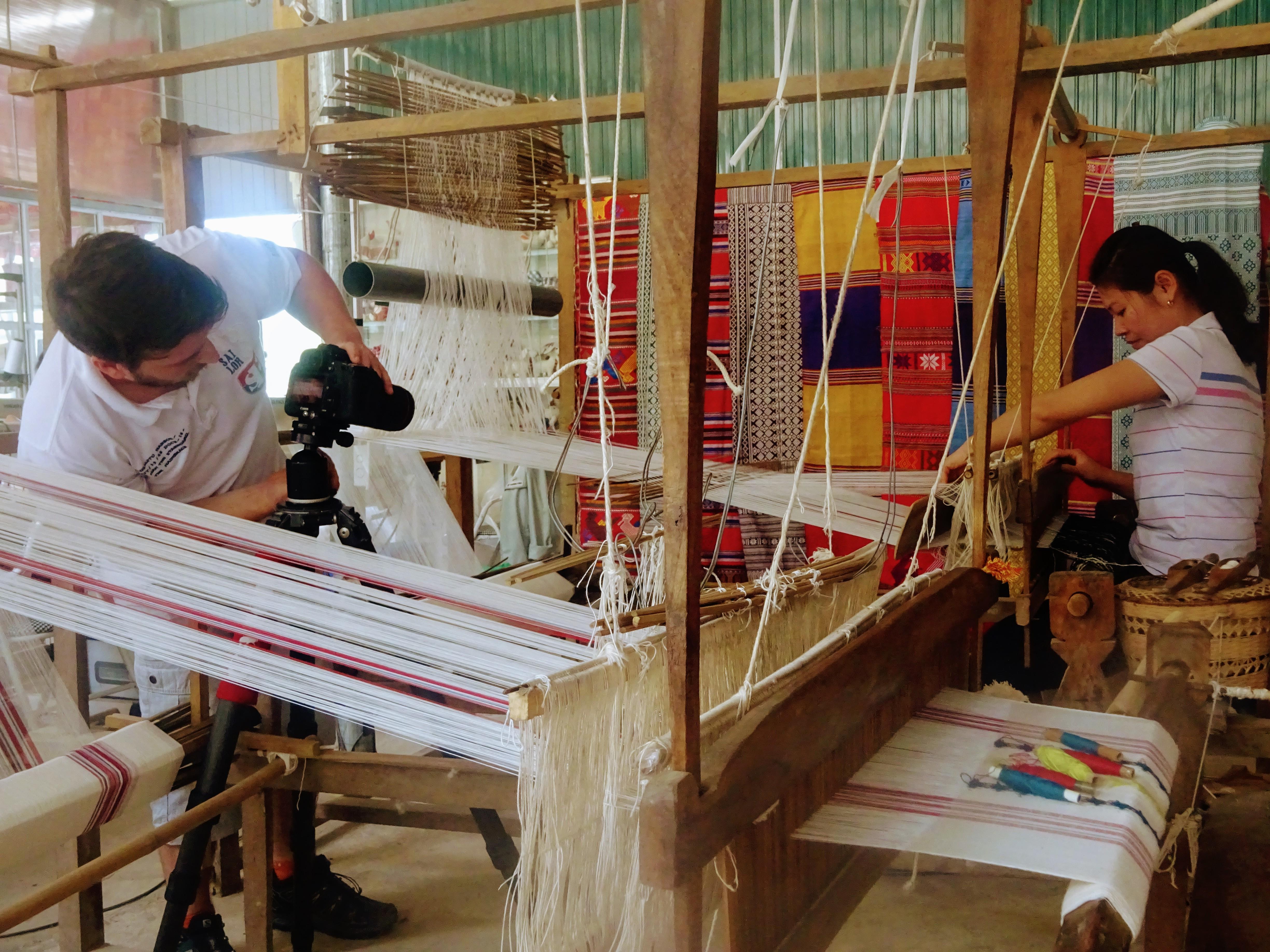 Male Projects Abroad Business intern photographs a local staff member weaving material during his Business Internship in Vietnam. Business intern photographs a female staff member weaving material for a product at a workshop in Vietnam.